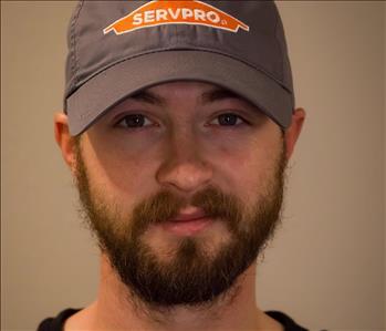 SERVPRO employee in front of beige wall