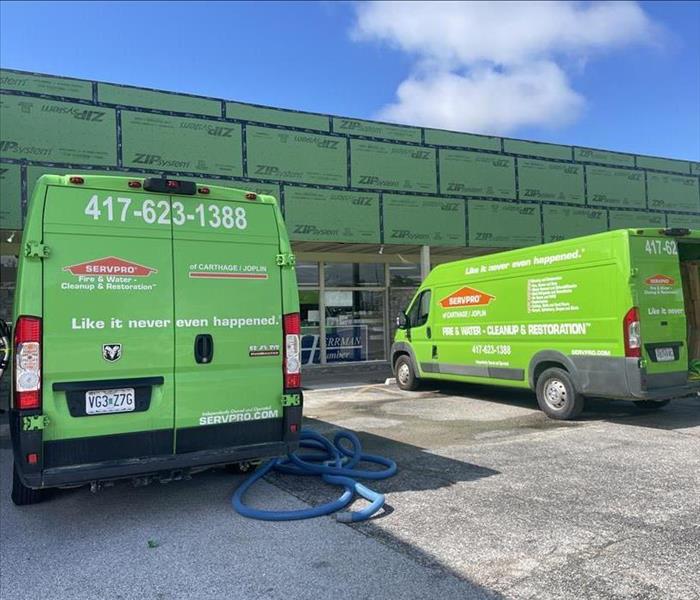 Two SERVPRO vans outside a business.